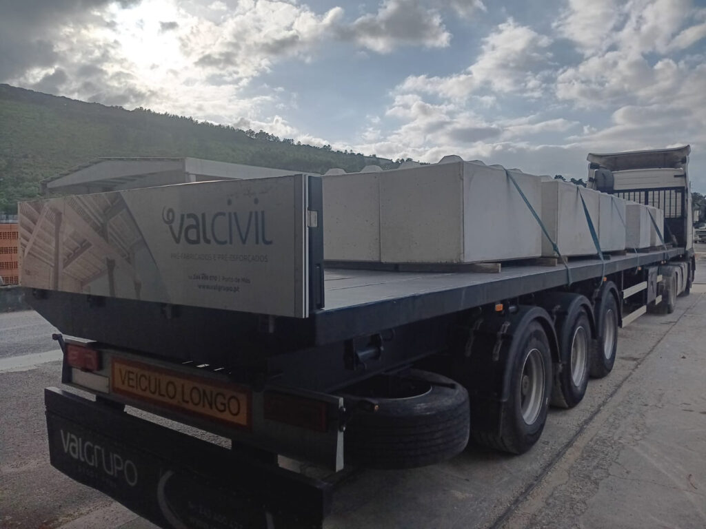 Camião de transporte carregado com elementos pré-fabricados de betão.